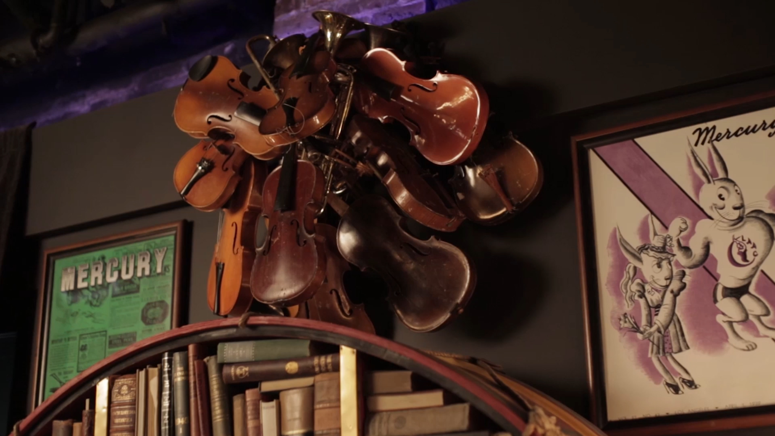 A collection of vintage instruments and books displayed on a wall. A nostalgic blend of music and literature.